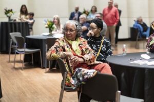 A woman listening to a speaker at a Distinguished Lecture Series Event