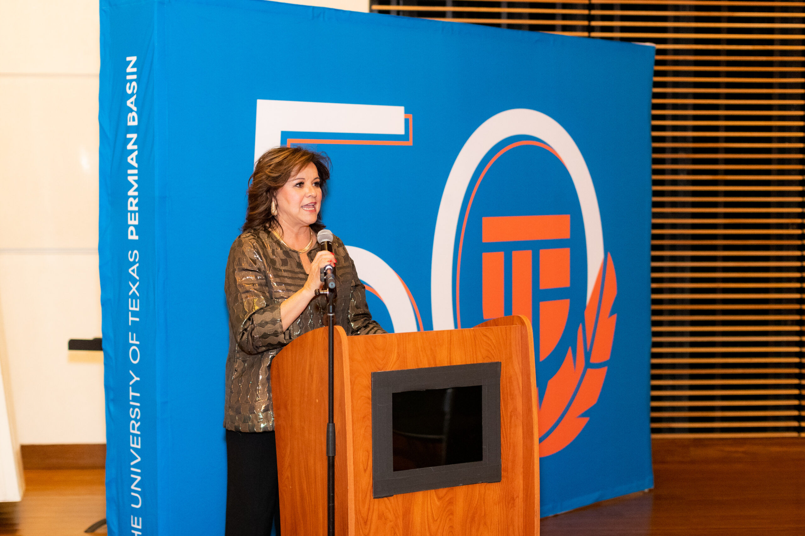 Monica Tschauner introducing at a podium